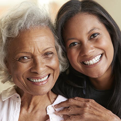 mother-daughter-hugging-smiling man smiling in park